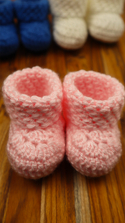 pink booties with blue and white in background
