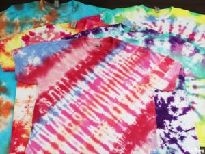 several tie dye shirts piled together