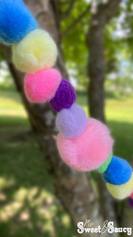 pom pom garland hanging from the tree close up